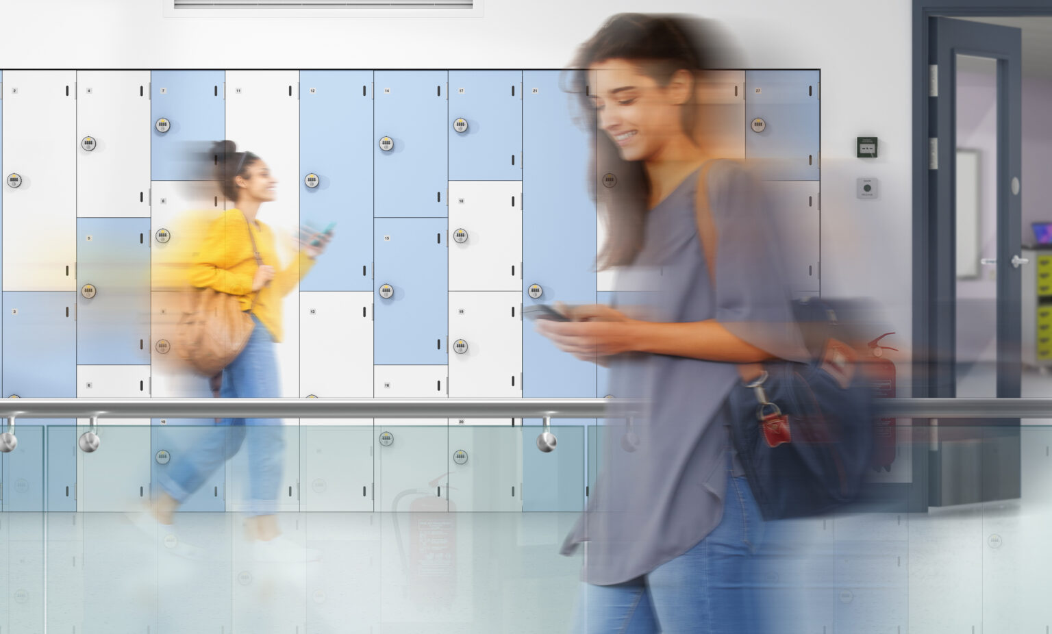 An image of two women passing by some storage lockers